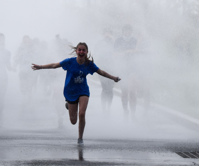 *When it rains it pours...Bursting through streams of water at the April Showers fundraiser, Freshman Kendra Yerger shows her support for Special Olympics. Souderton didnt let he cancelation of annual events due to COVID-19 rain on their parade, but instead found ways to give students safe, lasting memories. Photo reprinted with permission from yearbook staff.*
