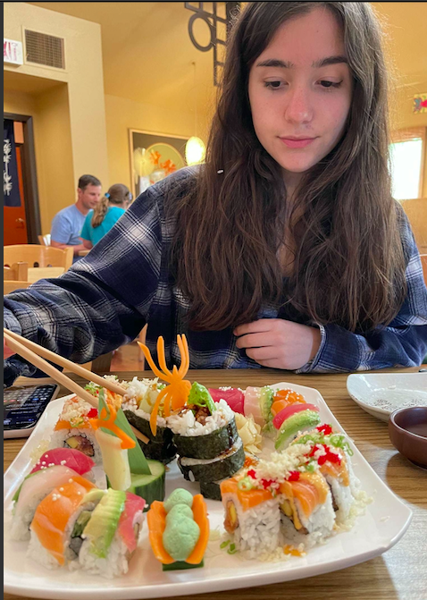 ***Full of flavor...**Plucking a california roll from the platter, Sushi lover Julia Vizza awaits a flavorful mouthful. The plate was filled with three sushi rolls from Tokyo Japanese Restaurant.*