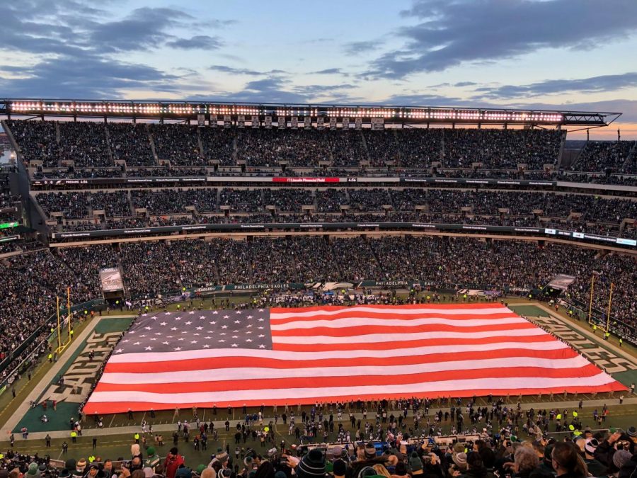 ***Broad stripes and bright stars...****Displaying the flag, military members and families show their patriotism before an Eagles game while the national anthem plays.*

*Photo reprinted with permission from Dave Schofield*