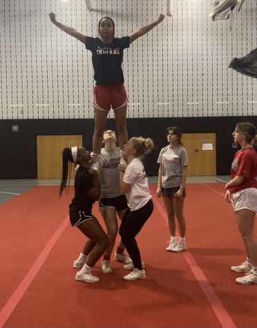 Rising back into regularity…With fewer pandemic regulations currently in place, the cheerleading team practices their stunting as preparation for the competition season. Co-captain Mia Bennett is held in an extension.