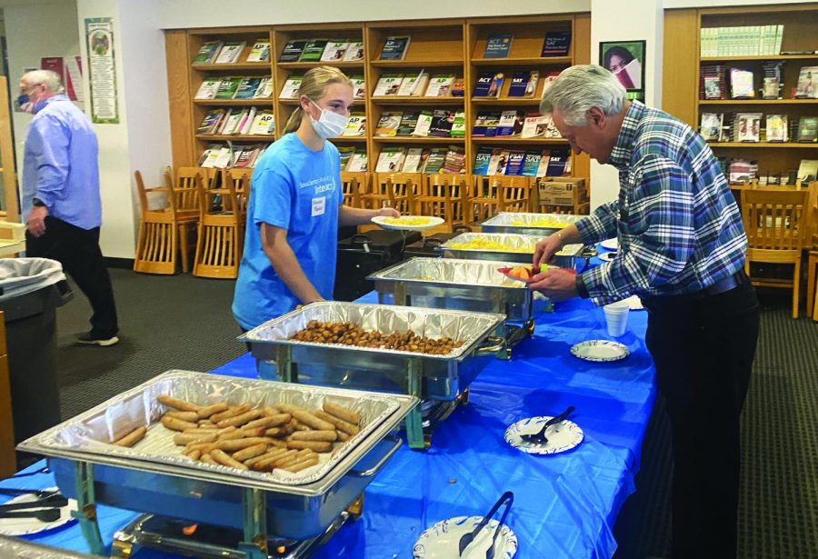 Get it while it’s hot...Making conversation while serving breakfast, junior Natalie Rankin chats with veteran Bruce Hengey during the Interact Club’s veterans brunch on November 13.