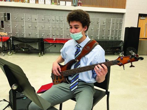 Strumming for perfection...Practicing for the first jazz band concert of 2021-2022, held on November 16, junior Nathanael Brown plays his electric bass. The school plans to continue indoor concerts in the spring.