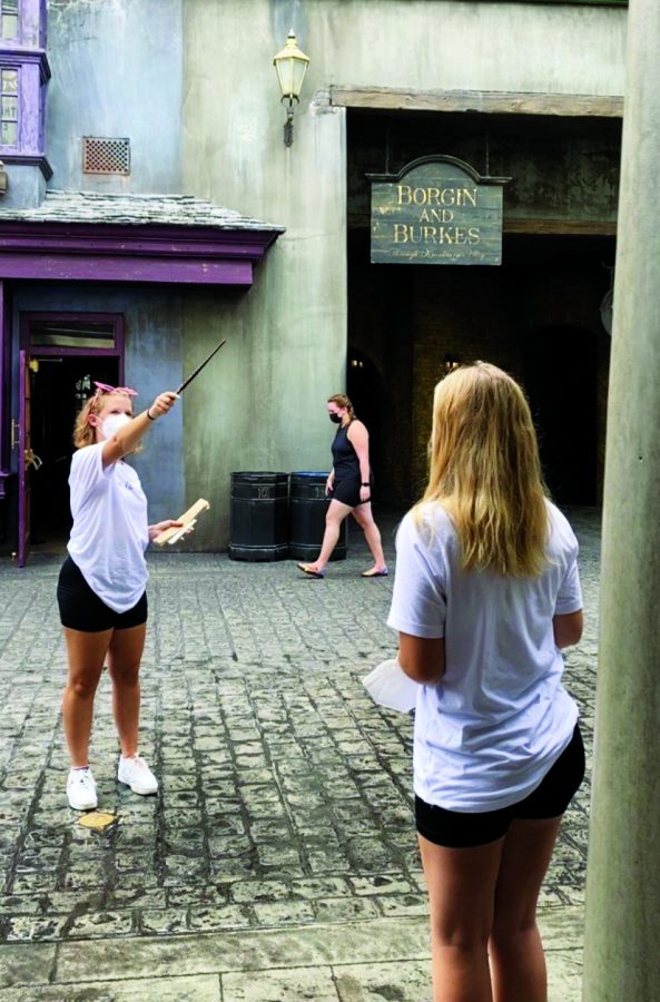Casting a spell...Waving their wands in Diagon Alley, freshman Grace Lomas (left) and junior Ahna Lomas complete the Interactive Wand experience at Universal Studios, Florida. Both Potterheads watched the Harry Potter 20th anniversary reunion special.