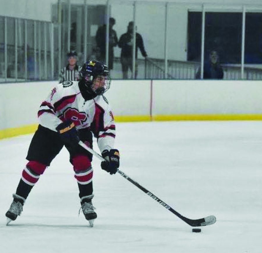 He shoots he scores…Preparing to shoot the puck, freshman Nick Smith skates across the ice during the game. 