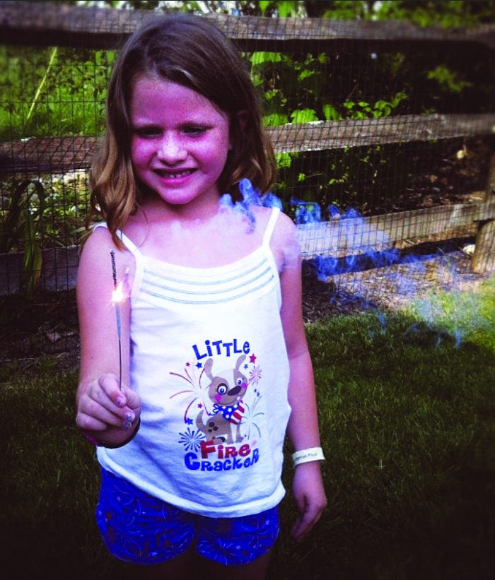 Born to be wild...Lighting up a firecracker, 5-year-old Madison Stine celebrates the Fourth of July. Growing up without overbearing parents fosters independence.