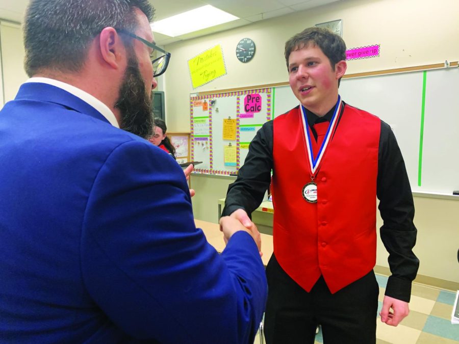 A proud moment...Congratulating him on his solo award, band director Adam Tucker (left) shakes senior Nick Mancini’s hand. The jazz competition was held on February 25 at Central Bucks West High School.