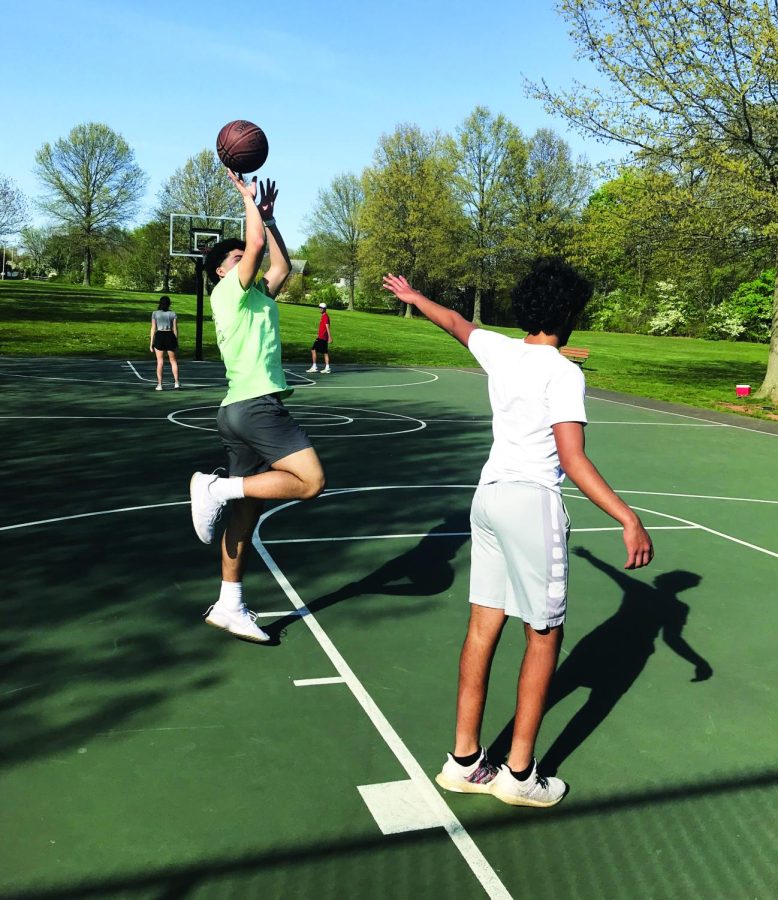 Shooting his shot…Playing a game of pickup basketball, junior Jon Kamaratos shoots a fadeaway jump shot while being guarded by junior Arjen Mamtani. The two were playing pickup basketball on a sunny day at the Church Road Park in Skippack.
