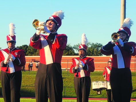 Blast off...Working through their march, freshman Sage Munden, senior Michael Stopyra, freshman Thamir Santos and freshman Sarah Stratton perform their pre-game show. This performance took place on September 23, and the marching band will continue with this show until November.