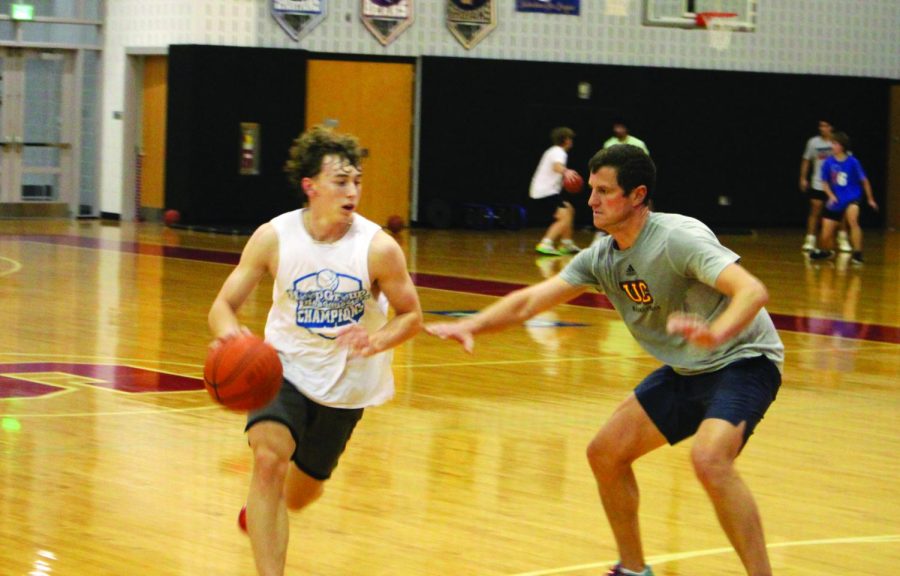Get your head in the game…Dropping low to guard, athletic director Dennis Stanton (right) blocks the path of senior James Blair. The 3v3 tournament allowed students and staff to be active together.