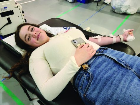 Not in vein…Laying down, sophomore Abby Nyce donates blood during the American Red Cross Blood Drive held at the high school on November 15. Nyce decided to donate to help people in need.