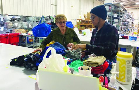 Sorting and serving…Organizing donations, volunteer Nancy Greene (left) and coordinator Jorden Powell give back to the community. They make care packages for people in need. 
