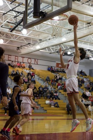 Putting up points...Laying the ball in for his team, boys basketball player Nathan Hemsing plays against North Penn High School at the Coaches vs. Cancer game on December 16. 