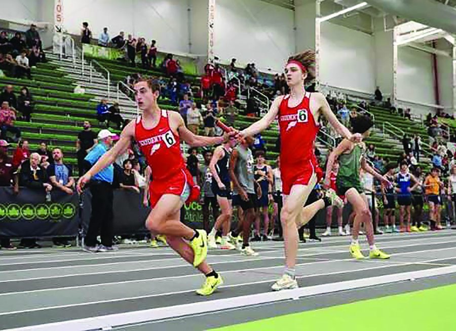 Pass the baton...Finishing his leg of the 4x800 meter relay, senior Nathan Fickert (right) hands the baton to junior James Kuduk. Boys winter track athletes competed in the Nike Indoor Nationals from March 10-11.