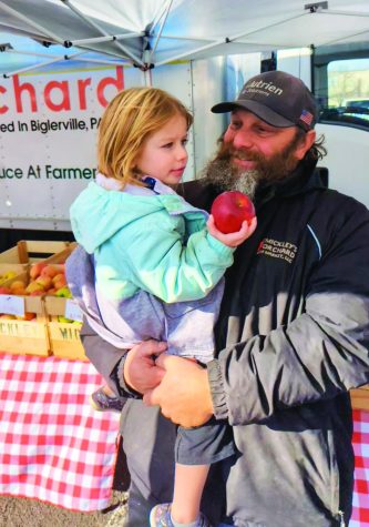 Sharing the wealth…Admiring the fruits of their labor, Mickley Orchard’s owner Bill Mickley and the orchard’s helper, Sophia Breish, share their apple harvest at the Lansdale Farmers’ Market.