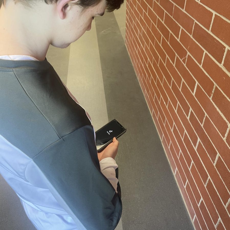 Scrolling+away...Opening+TikTok%2C+sophomore+Liam+Aldredge+uses+his+phone+to+search+for+various+videos+on+TikTok.