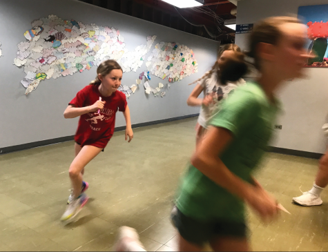 Sole-searching…Warming up for practice, sixth graders Johannah Gehret (left) and Elli Watson run laps while pondering a question posed by the Girls on the Run coaches. At practice on April 13, the team reflected on their individual qualities and what they look for in a friend. 
