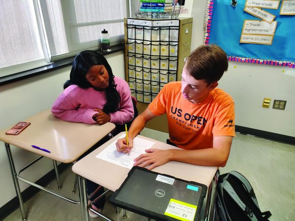 Crunching numbers…Working together, senior Jacob Dommel and junior Isiyah Mcfadden complete a worksheet on economic principles during an Economic Challenge Club meeting on October 5. The club meets once a month during Red Zone to expand their knowledge on the economics of the world. 