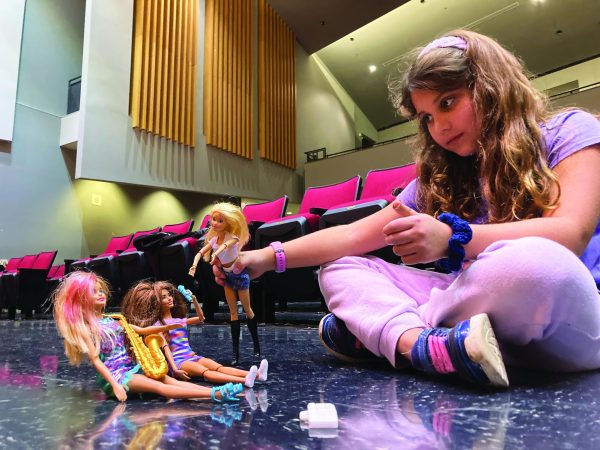 She’s a Barbie girl…Playing with her Barbie dolls, first grader Kaylee Simpson holds a makeshift concert.