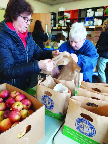 Boxing it up…To manage the Saturday rush, E-meal organizer Ann Marie Heidgerd (left) and volunteer Janet Shepherd pack lunch bags for families on January 6. Emmanuel Lutheran Church started the E-meal program in 2020 and has given out over 500,000 meals to people in need.
