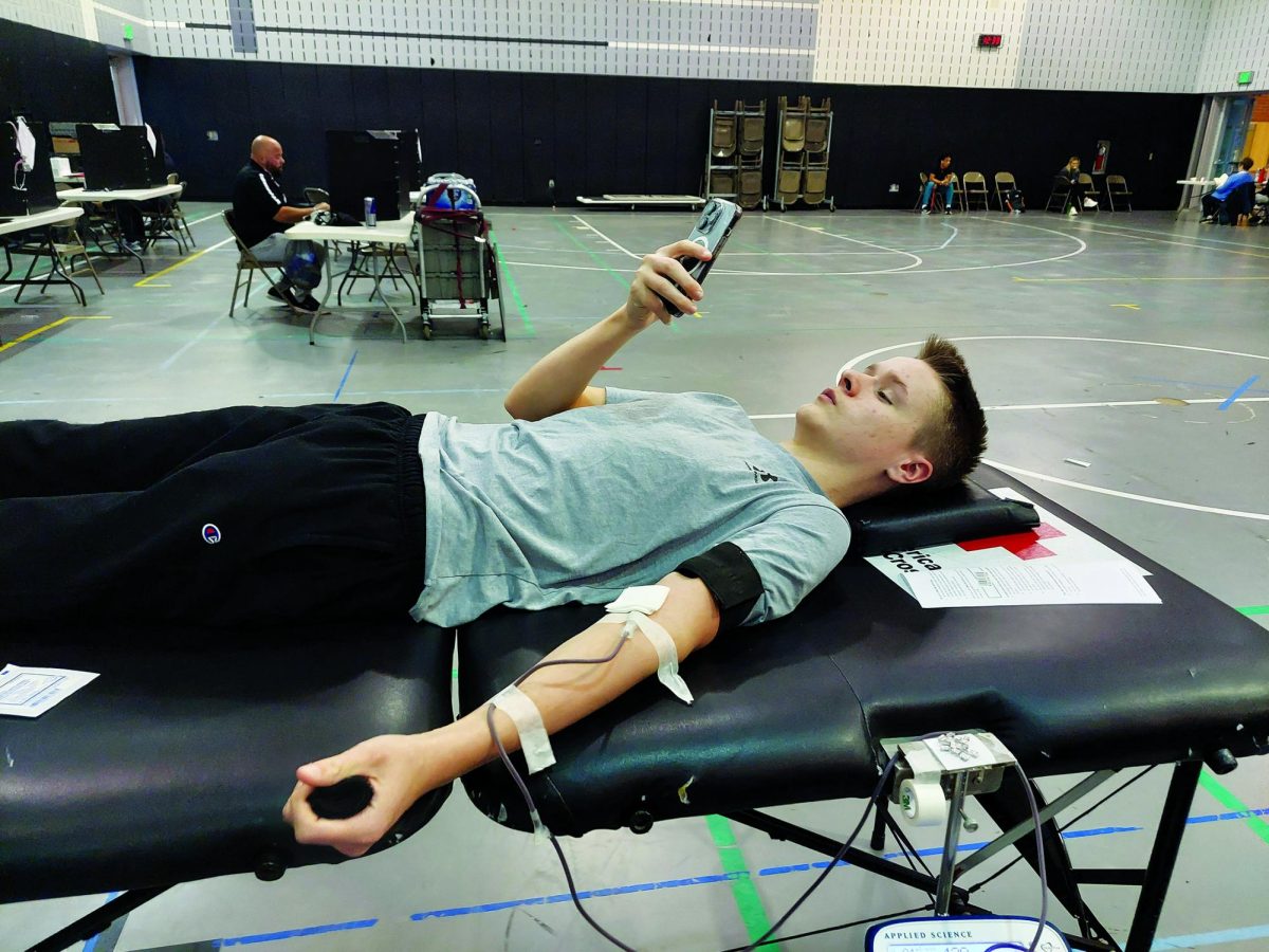 Think ‘positive’ thoughts…Donating blood on April 9, junior Brad Peck lays on a gurney in the high school’s auxiliary gym. 