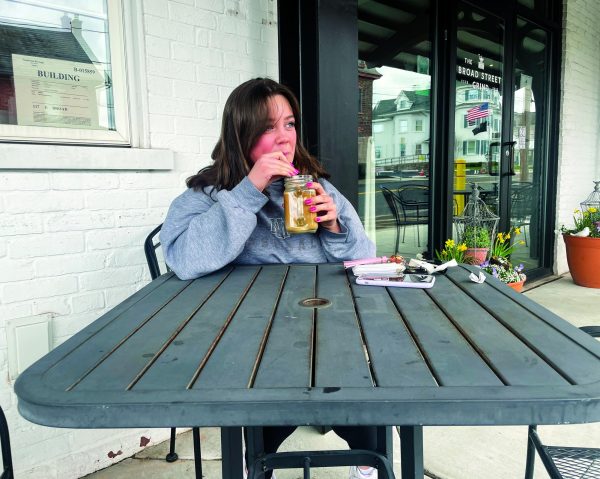 Spring time is here…Enjoying a French vanilla iced coffee outside, junior Abby Nyce takes advantage of the spring weather in the outdoor seating area at The Broad Street Grind in Souderton on April 2. 