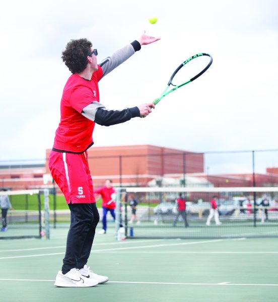 Delivering a knockout blow…Serving the ball during an April 5 doubles match against Central Bucks West, senior Chase Walker competes for his team. Souderton lost 7-0.