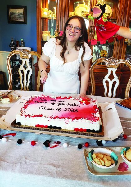 And cut…Marking the end of high school, alumna Helen Spigel slices her graduation  party cake. Spigel graduated in 2023 and celebrated the occasion in June of last year.