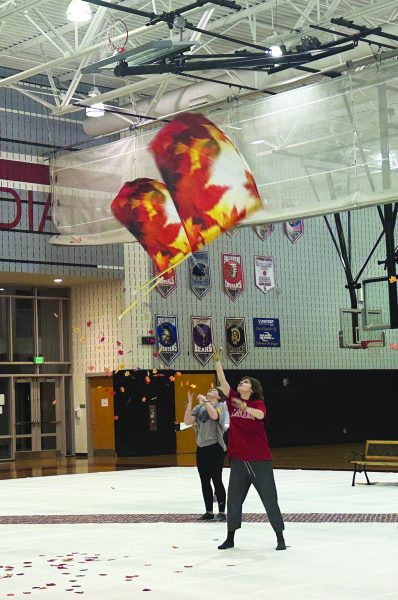  Flag spinning… Practicing their flag toss, junior Sarah Ralston is preparing for the upcoming competition by working on their technique. Indoor color guard competitions occur on various Saturdays until the first week of May.