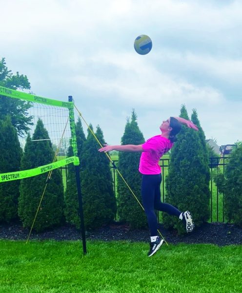 Serving up summer right…Improving her volleyball skills, freshman Arden Barzousky works on her serves. Barzousky practices at her home volleyball court.