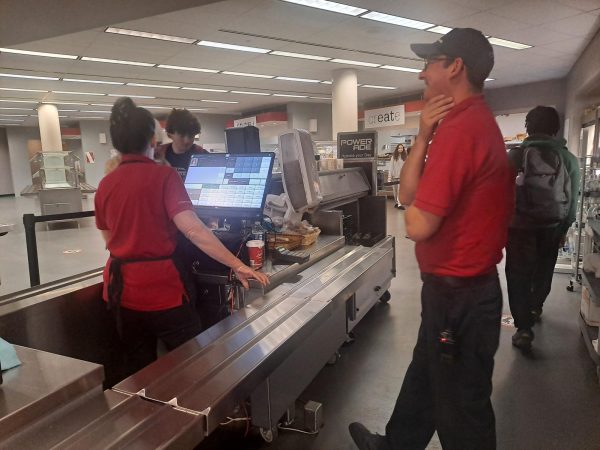 Checking it out....Supervising the cafeteria checkout line, cafeteria manager Pete Krall steps into his new position. Krall has started with menu changes and the “grab-and-go” area.