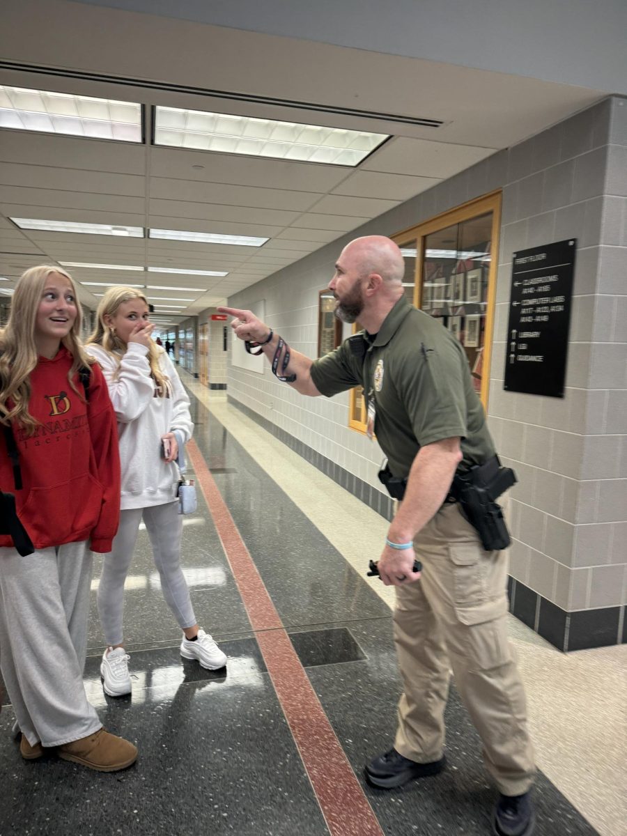 Guarding...While making his daily rounds around the building, new school police officer Todd Wright jokes around with  sophomore Jules Petrovitch (left) and senior Audrey Hughes.