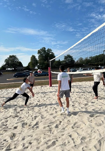 Providing an after-school physical activity for students with a love for volleyball, special education teacher Suzanne Holcombe advises the volleyball club.
According to Holcombe, the club meets on Thursdays after school from 3:50-5p.m. at the volleyball sand court outside near the practice football field.
Holcombe said that you don’t have to have any experience before joining the club, you can “just join.”
“The club will not teach you how to play volleyball,” Holcombe said. “The club is co-ed so anyone can join.”
For freshman Ellie Tisoskay, the club is not for competition but rather a chance to make friends.
“I go to hang out with friends, and just have fun,” Tisoskay said.
Some people were nervous to join the club at first, but once they joined they found it was not as intimidating as they thought.
“I like how accepting it is,” Tisoskay said. “I was nervous at first to join since I’m not that good but it was not as bad as I thought.”
According to Holcombe, she does not play for the team but enjoys watching the students have fun without any real sort of competition. 
“I enjoy watching the kids play,” Holcombe said. 
There are many reasons as to why people join the club. 
Some people joined because they wanted to get better at a sport they love.
“I joined because I wanted to get better at volleyball, and make the school team next year,” freshman Savanna Washington said. 
There are a lot of skills that are important when it comes to volleyball, and for some people, they have a favorite. 
“My favorite skill in volleyball is spiking,” Washington said.
Some people in the club have played volleyball for clubs, teams, or just for fun before joining the club. 
“I played volleyball for Cal volleyball club in seventh to eighth grade,” Tisoskay said. 
Holcombe has been playing volleyball for a couple of years and used to play for her school.
“In the past, I played volleyball for my high school and I played for around four years,” Holcombe said. “I went to a high school on Long Beach Island.” 
Holcombe’s favorite part about being able to coach the team is being able to “sit outside and watch the kids play,” Holcombe said. 
The number of people in the club varies depending on how many people show up and it takes six people to be on a team. 
“We usually get anywhere between 12 to 24 kids,” Holcombe said.