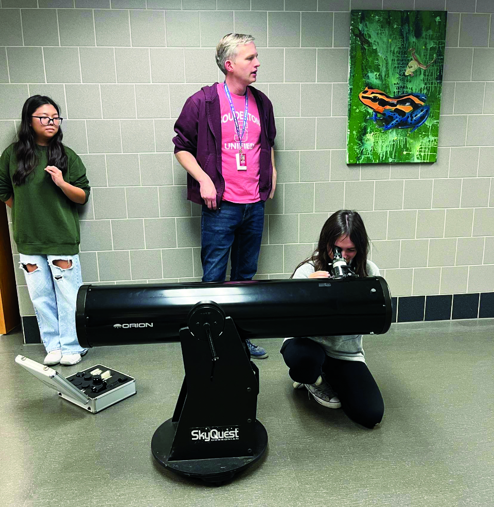 Expanding horizons…Observing the stars, juniors Nadia Choe (left) and Izzy Shurtz look through a telescope provided by Astronomy Club advisor Patrick Murphy during the meeting on October 23. Discovery Club reached out to Astronomy Club to broaden students’ horizons. 
