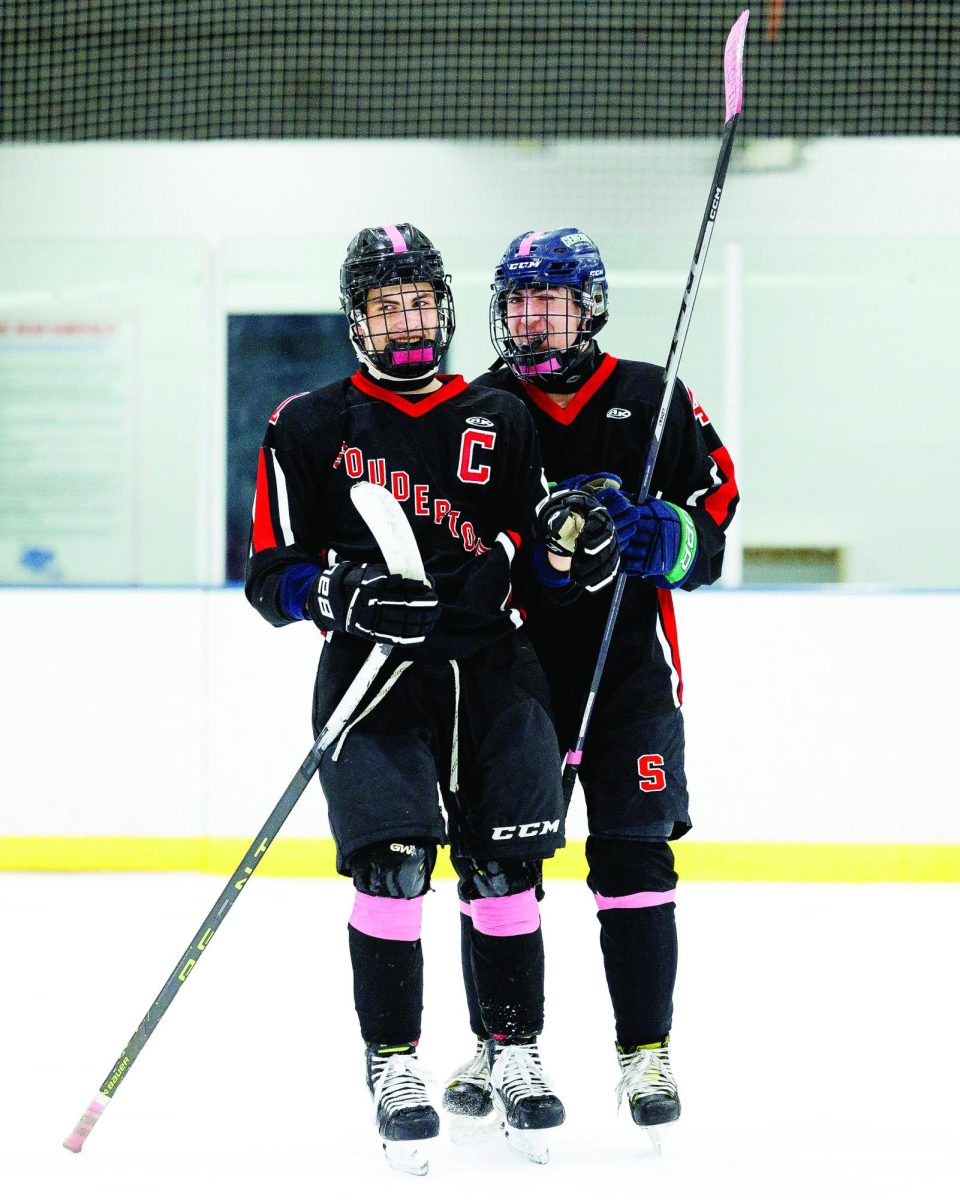 Taking it in…Before their November 13 game at Hatfield Ice Arena in Colmar, seniors Nick Smith (left) and Luca Ferretti are suited up, ready to play. The boys hockey team beat Central Bucks West High School with a score of 14-4.