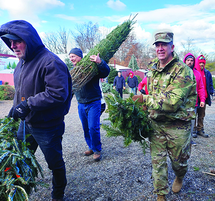 ‘Root’ed in community...Loading donated trees into a FedEx truck on December 5, Brigadier General Mark Goodwill represents the Pa. National Guard at Pennsylvania’s annual Trees for Troops event, hosted this year by Bustard’s Tree Farm in Lansdale.