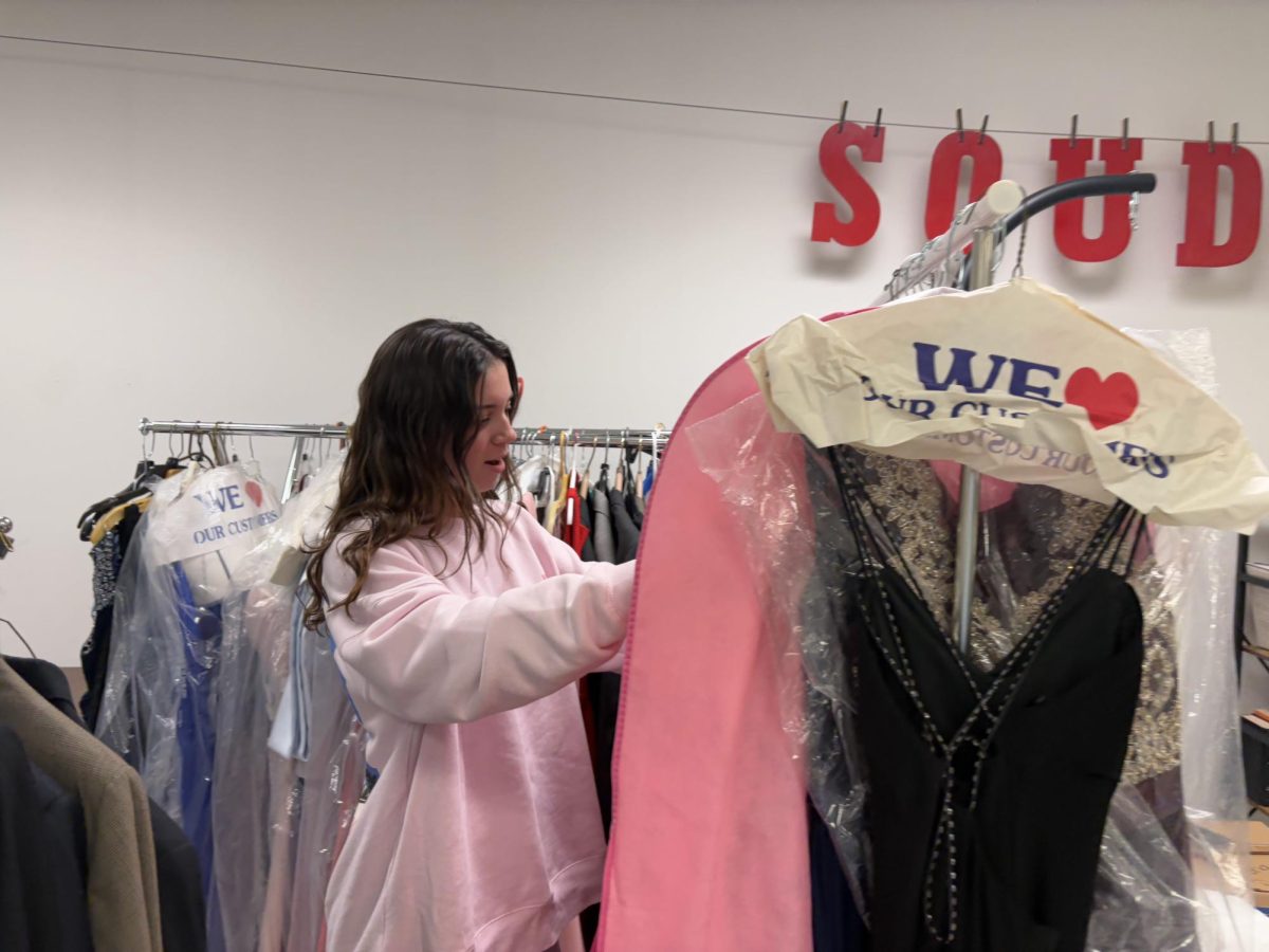 Dozens of options… Browsing through dresses, junior Jackie Lee looks through all the donated dresses available. The attire is in room A113, where students can choose dresses to go to school dances for free.