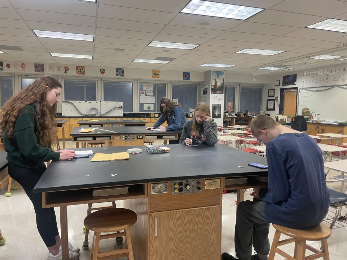 Faithful studying…Discussing and engaging in their meetings discussions, Movement Club members (left to right) together to deepen their understanding of religious text and do biblical cards.