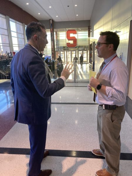 Discussing… Principal Sam Varano and 9th and 10th grade principal Jeremy Miller meet in the hallway. They both stand in front of the new decals around the school.