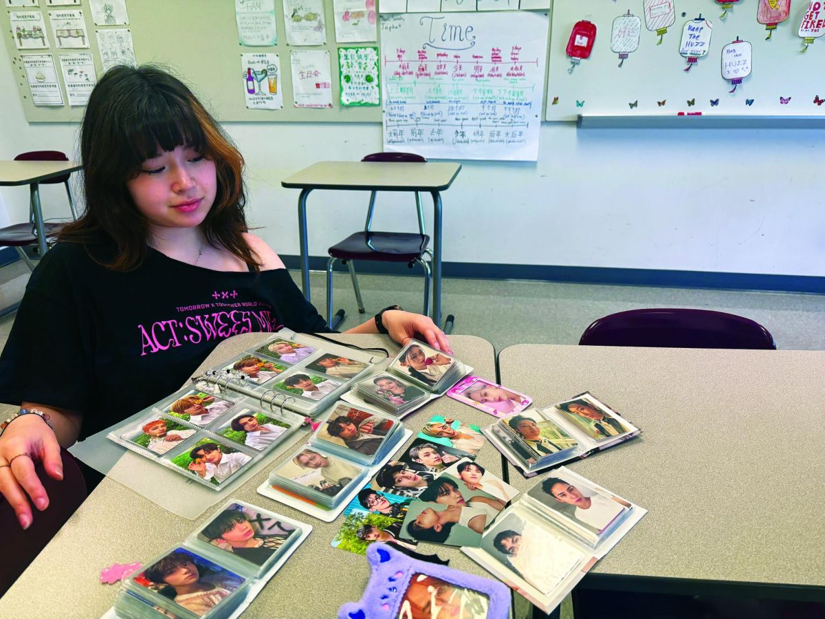 Card collecting...Organizing K-pop photocards, senior Ali Eng shows off her collection in the Mandarin classroom. Her PVC-free binders offer sleeves that will not strip cards of color.