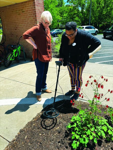 Pinging…Testing out the metal detector from the IVPL’s Library of Things, outreach services librarian Nicole Husbands (right) searches for lost items while library director Tracey Reed assists. The Library of Things is open for anyone with a library card.
