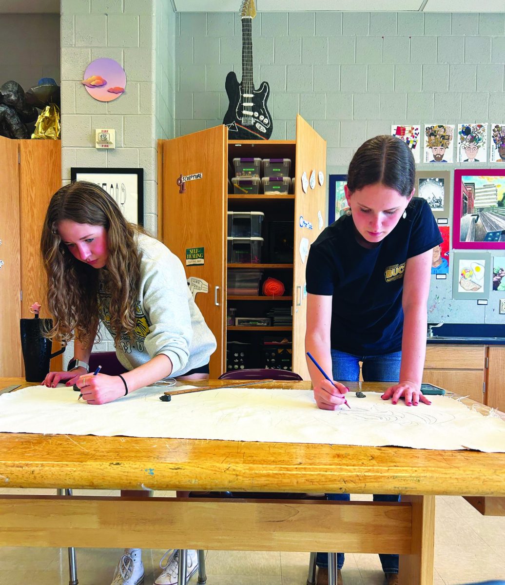 Drawing up school spirit...After school, juniors Kaylie Warshaw (left) and Leah Nolan bring to life to the White Team’s banner for Red vs. White.