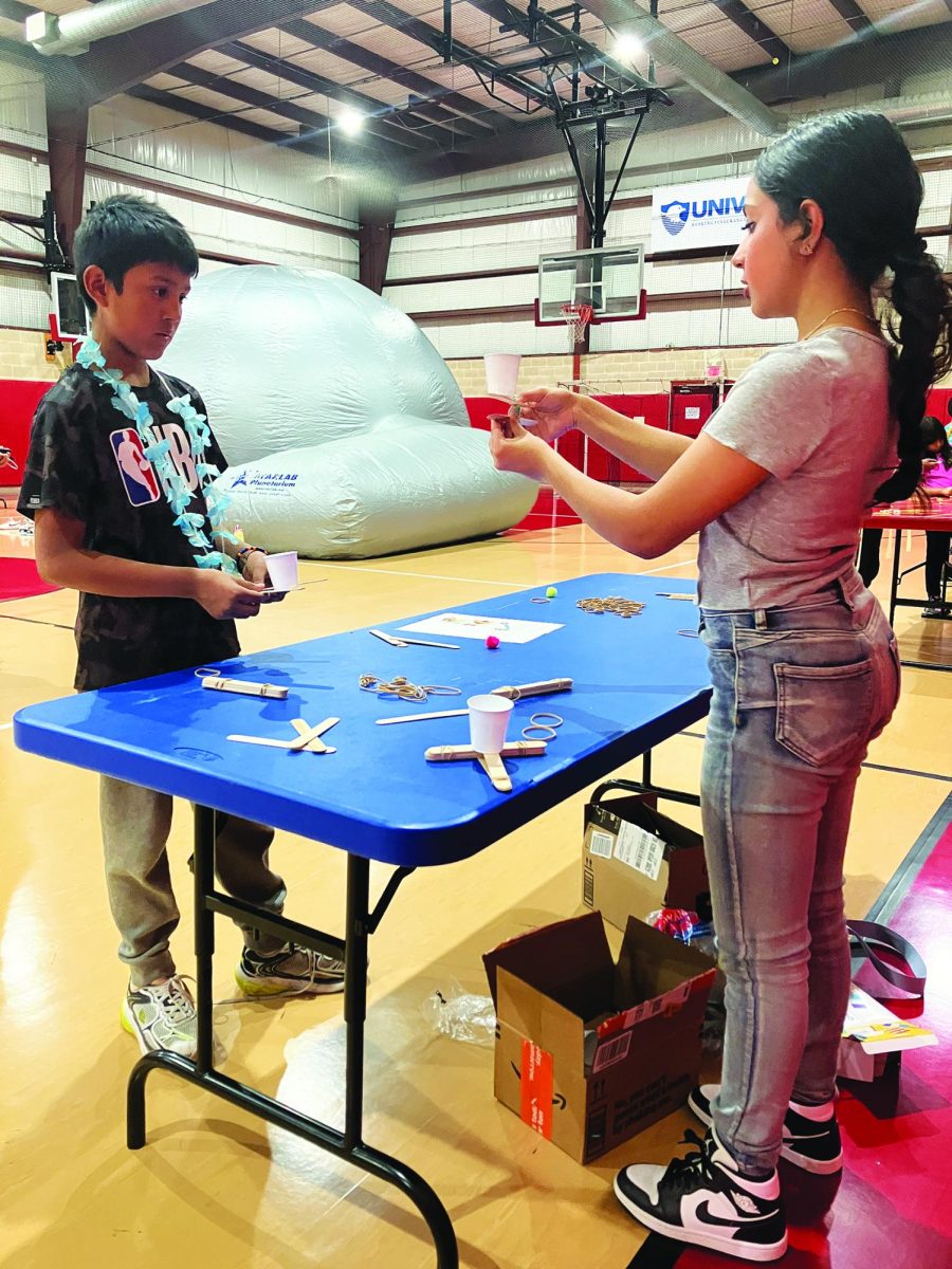 Getting creative…Taking leadership, second grader Adrian Ruwaya is being assisted by junior Aimal Ahmad (right) while making a catapult. The STEM Club Fair took place on May 2 from 4-5:30 p.m. at the Souderton Boys and Girls Club.