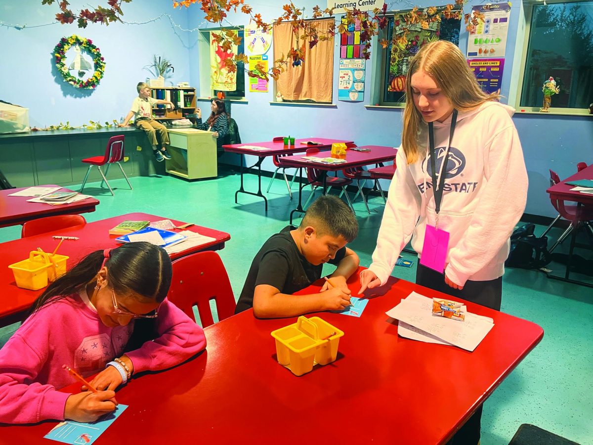 Advocating for themselves…Writing letters to representatives, 9-year-old Ashly Flores (left) and 9-year-old Moises Gomez receive help from CSO Zoe Mamzic during the letter-writing campaign at the Boys and Girls Club. Students wrote about issues in their communities and how to solve them, with the guidance of CSOs.