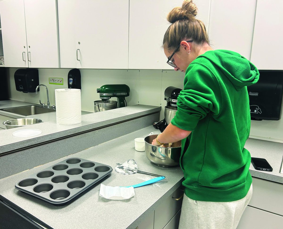 Baking off...Preparing cupcakes for the Holiday Baking Club, junior Ava Cevoli mixes in the dough. Holiday Baking Club meets once per month and donates treats to the community.