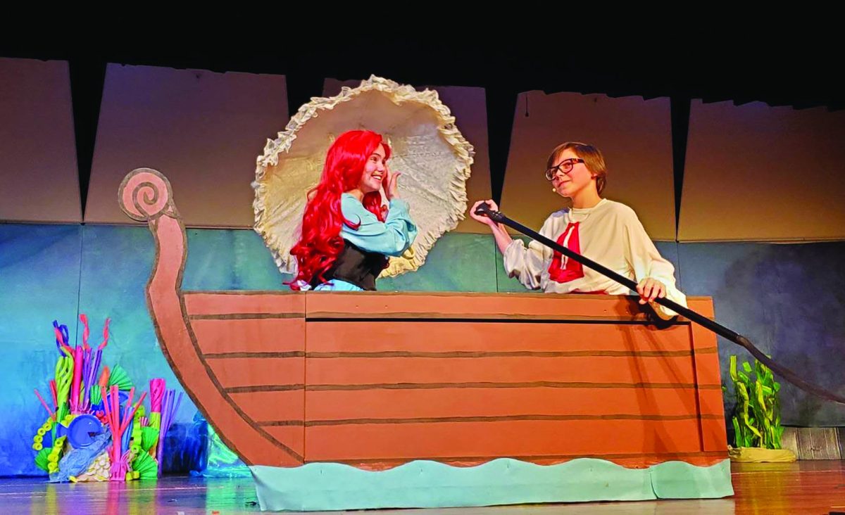 Under the sea…Rowing a boat through the water, seventh grader Tessa Nelson and eighth grader Fionn Shelly perform as Ariel and Prince Eric from “The Little Mermaid, Jr.” The scene occurs before the song “Kiss the Girl.”