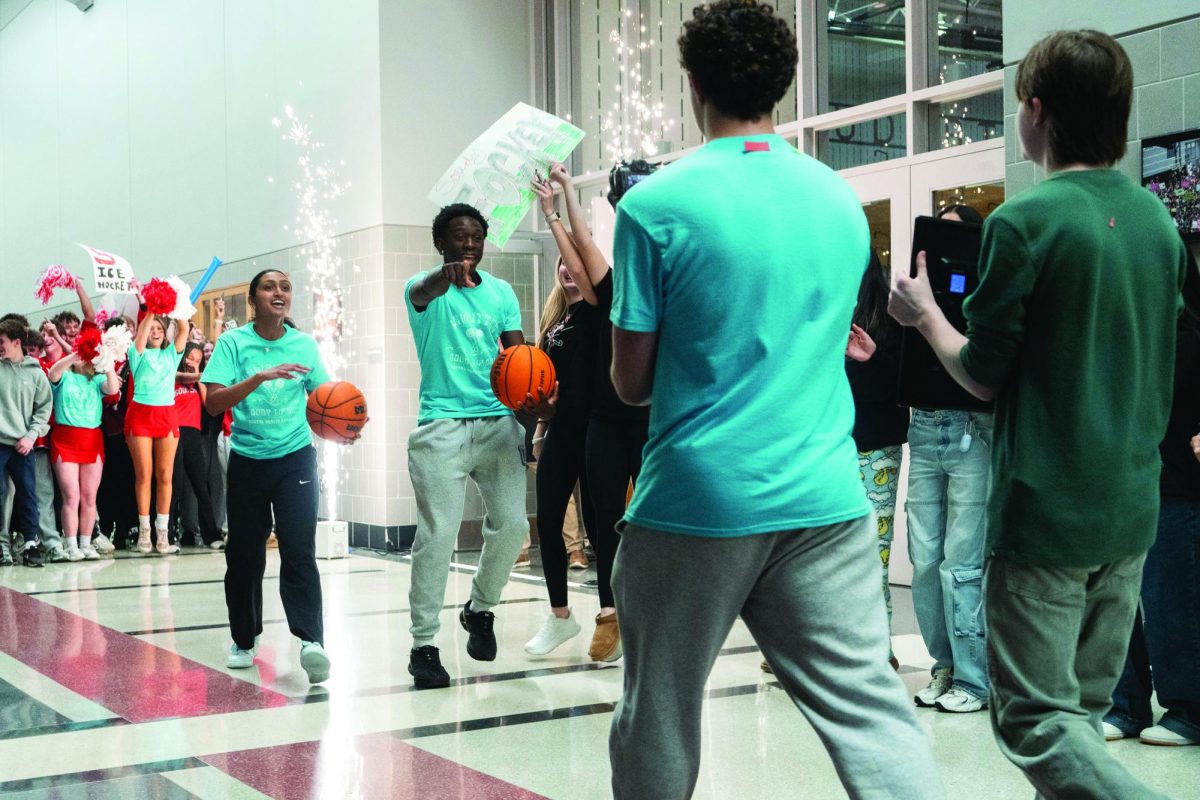 “The rest is still unwritten”...Lip syncing during the March 13 Lip Dub, (from left) seniors Mahi Patel and Nate Rusike highlight girls and boys basketball before entering the gymnasium.
