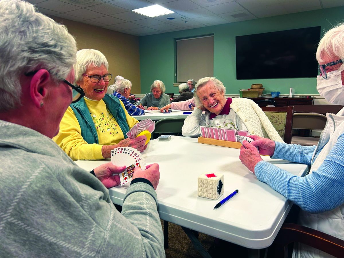 Raising the stakes…Getting ready to draw some cards, (from left) Souderton Mennonite Homes residents Bette, Sherrill, Evelyn and Mary enjoy family game night on March 3.
