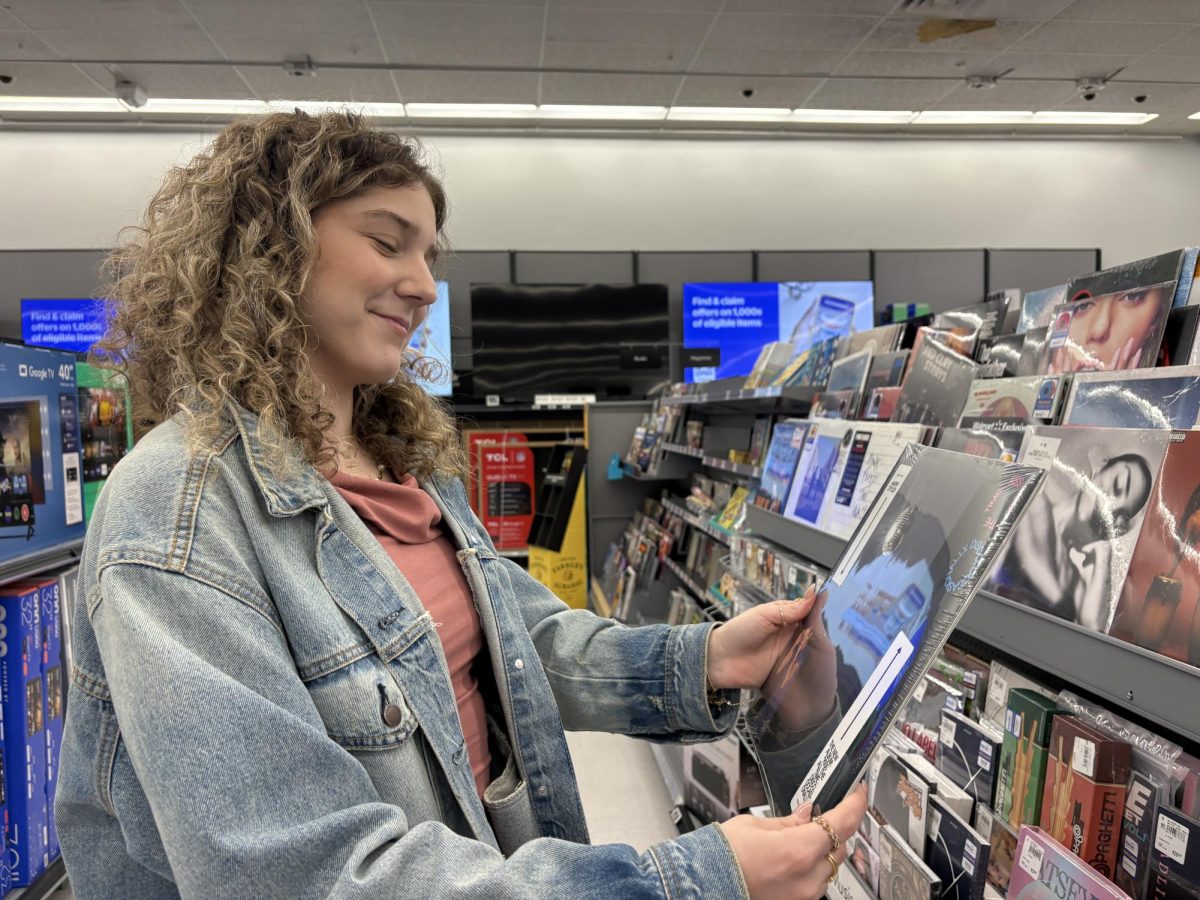 The disco era begins…looking at the album cover, senior Maya Bernhauser is holding artist Harry Styles' new record, “Kiss All The Time. Disco Occassionally,” after hard copies are available for purchase at Walmart. 