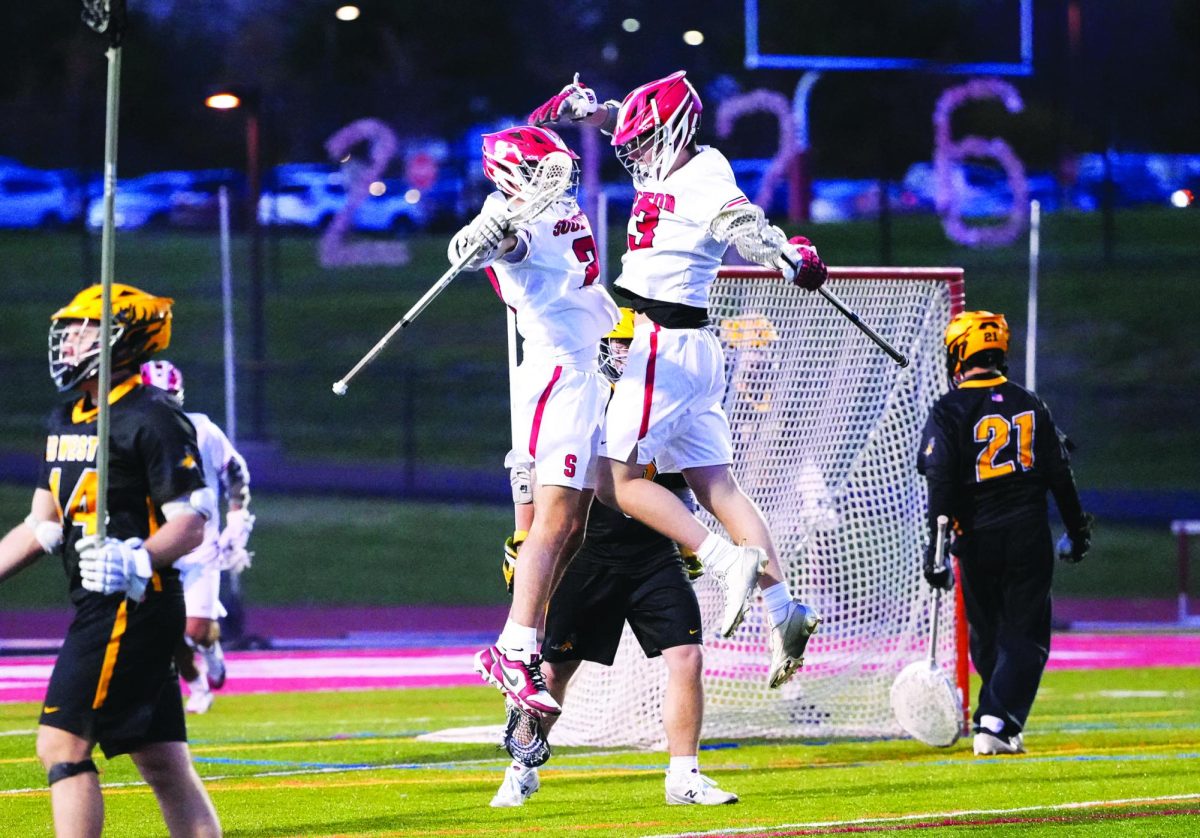 “Bar down”...Leaping in celebration, (from left) sophomores Chris Tuohey and Ty Sauerwald enjoy the moment after Tuohey scores a goal in a game against Central Bucks West High School. Souderton played Central Bucks West on April 9, earning an 8-6 win over their divisional rival.