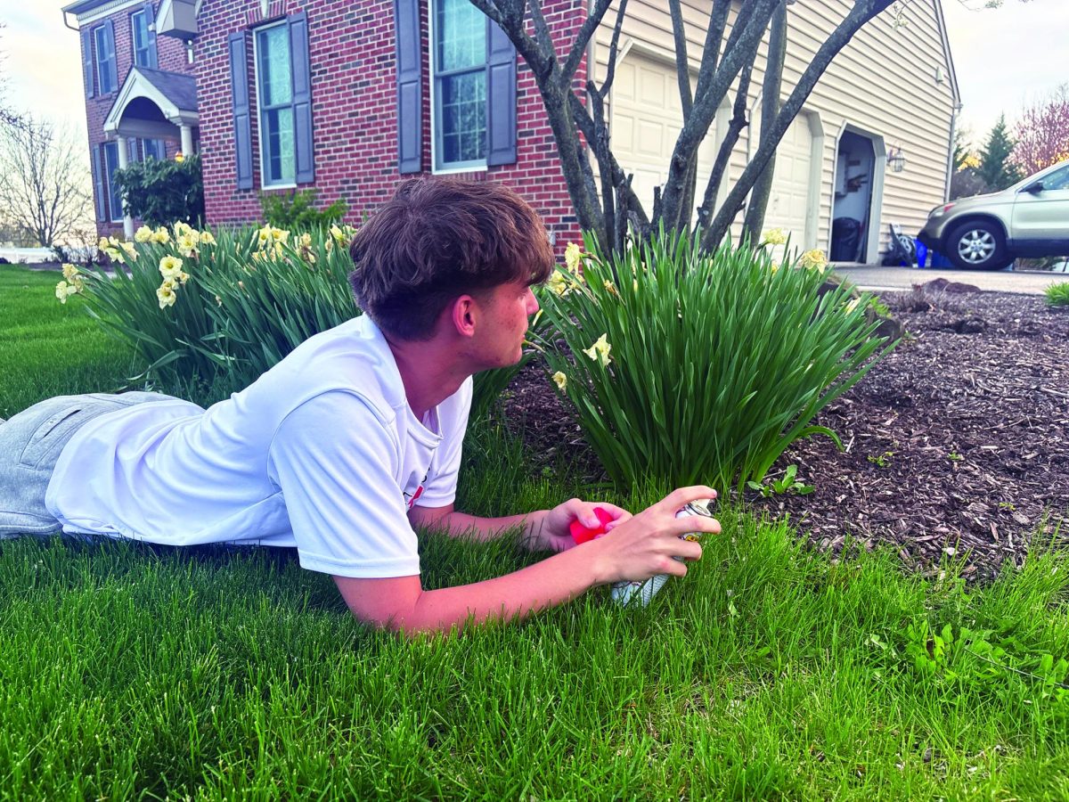 Going for the kill…Crouching down, senior Will Cusano uses silly string to try to eliminate his senior assassin target on April 10. Cusano attempted to secure his spot for the third round.